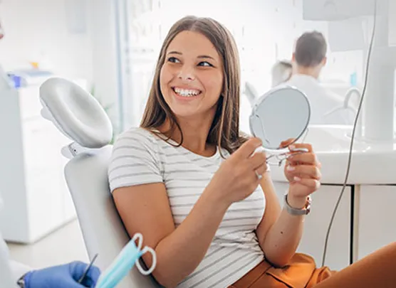 Woman examining her smile in a mirror